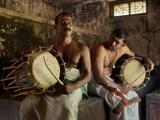 men without shirts playing drums