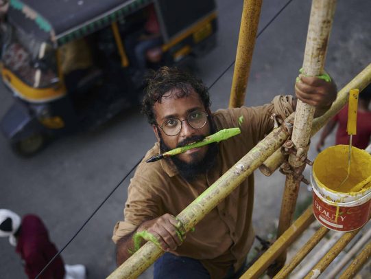 man with glasses holds between