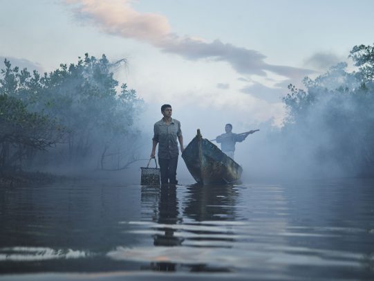 man aside of a boat with a man inside on a river for Lavazza Calendar 2016 by Joey L