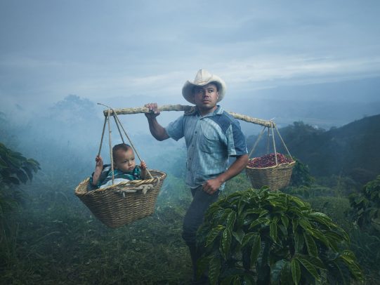 man holding two baskets with his son in one for Lavazza Calendar 2016 by Joey L