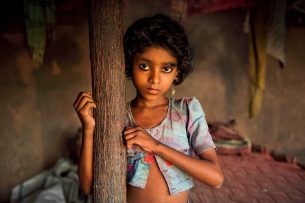 Young girl at a wooden pole