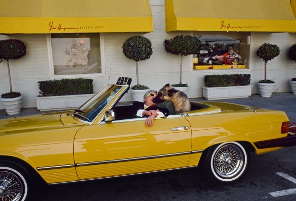 man with his dog in his yellow car