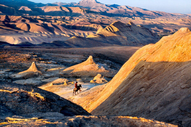 Man rides a donkey through the afghan desert