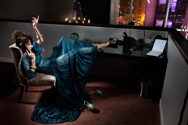 woman talking on the phone of her office with bare feet on the table