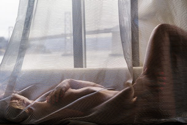 naked woman behind a curtain