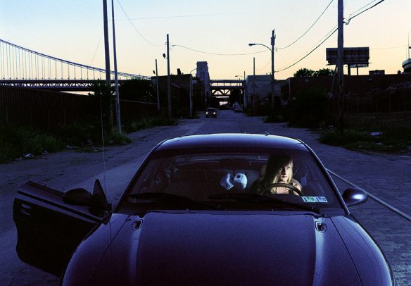 blonde woman alone in a car with big dice