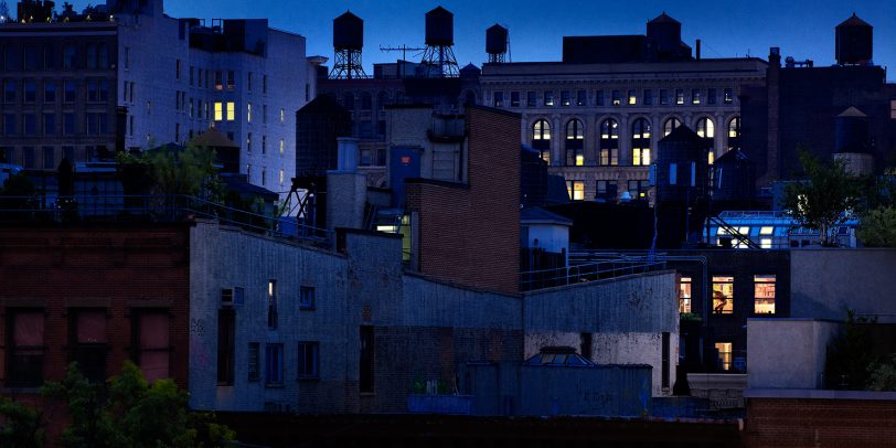 city at night and a woman through a window