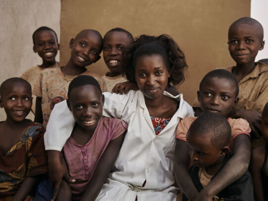 children smiling around a young doctor