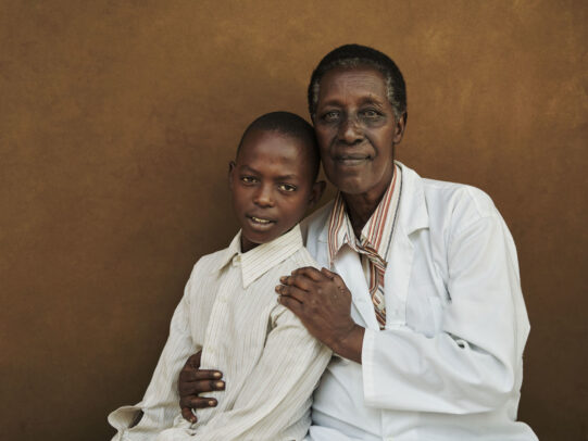a doctor and his young patient posing for Novartis annual report by Joey L. 