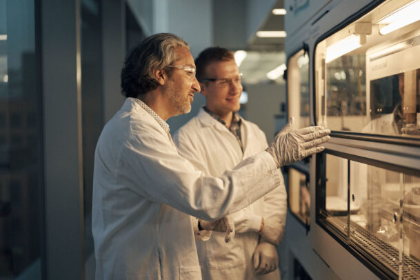 two doctors in front of a lab talking each other during Novartis annual report by Joey L. 