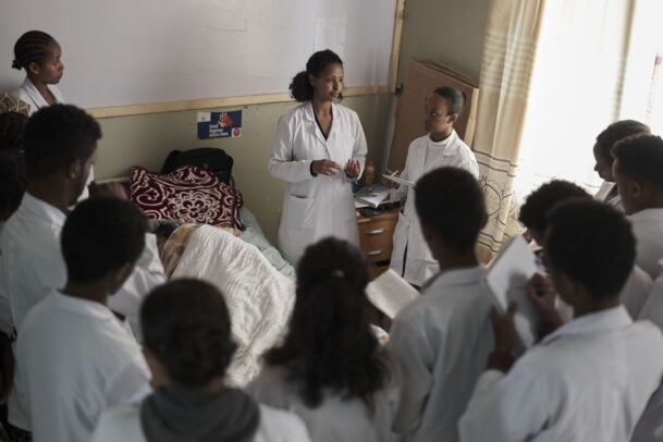 a doctor in hospital with her pupils and a patient in bed during Novartis annual report by Joey L. 
