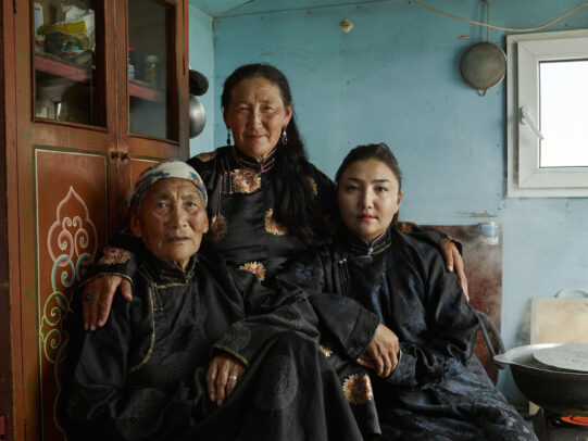 three mongolian people in a house 