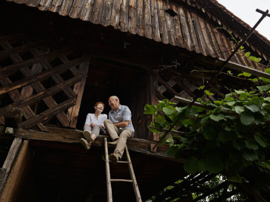 A doctor with her patient sitting on high ground with a wood ladder during Novartis annual report by Joey L. 