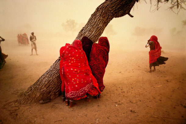 girls hiding in their saris and protecting from the dust storm