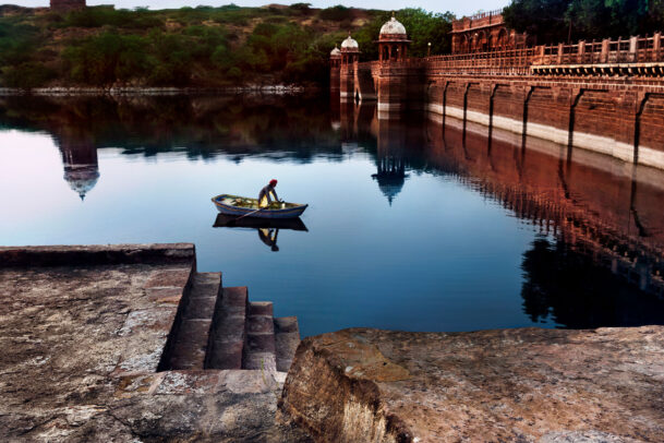 Man rows boat at dusk