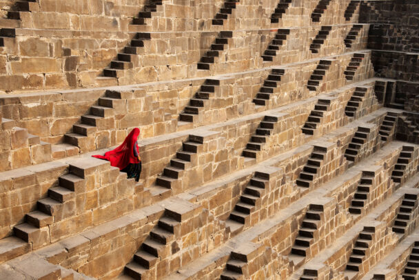 A woman walks down Chand Baori steps
