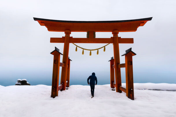 Man under japanese torii in gozanoishi Shrine