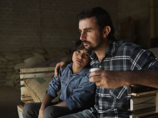 Man hugging his son and holding a cup of coffee on the pick up for Lavazza Calendar 2016 by Joey L