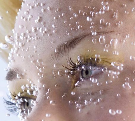 blue eyes of a girl underwater with bubbles