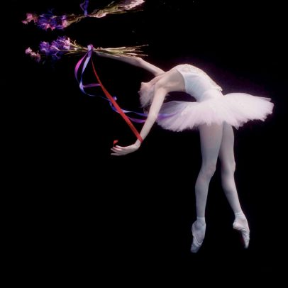 ballerina dancing underwater with a bouquet and a tutu
