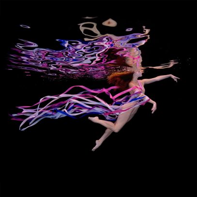 girl swimming underground with purple stripes