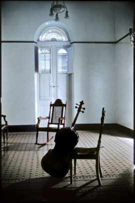 a cello leans agains a chair