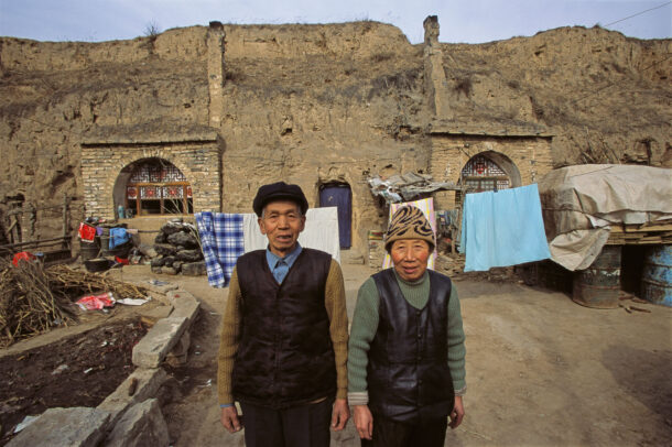 chinese man and women in front of their house