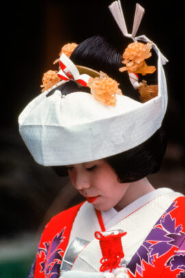 a japanese bride wearing the elaborate kimono and headpiece for the Shinto ceremony