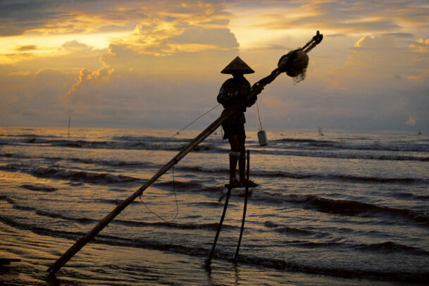 fisherman on stilts in the sea