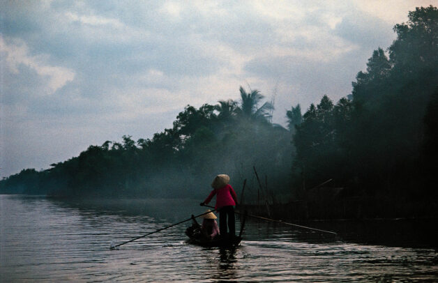 In the dawn haze, two women go to market in Camau, southern Vietnam.