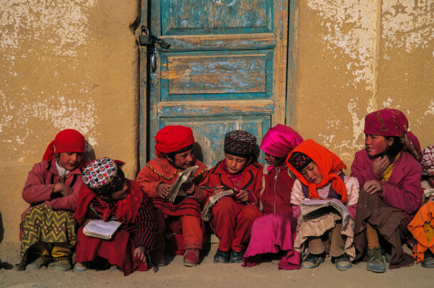 Tajik children review tattered class notes before school