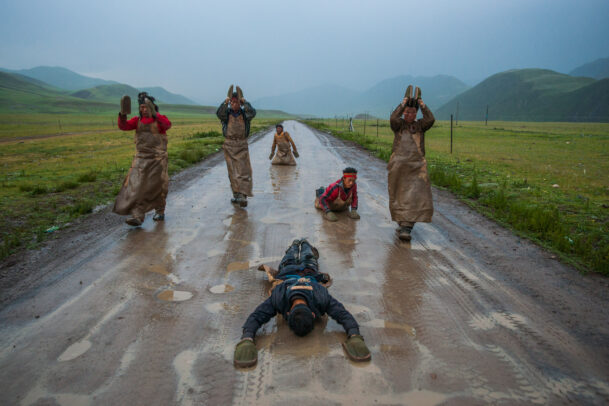 buddhist pilgrims prostate themselves on their way to Lhasa