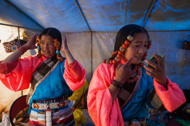 Tibetan girls decked in festival finery, turquoise, coral, and silver.