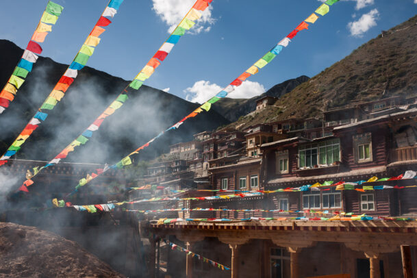 prayer colored flags near a building on a hill