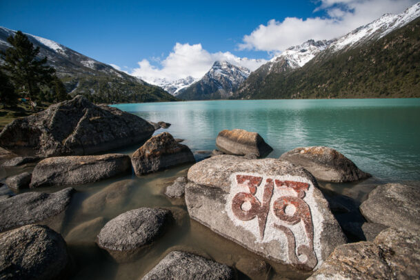 A mani prayer stone sits on the shore of Lhamo Latso lake