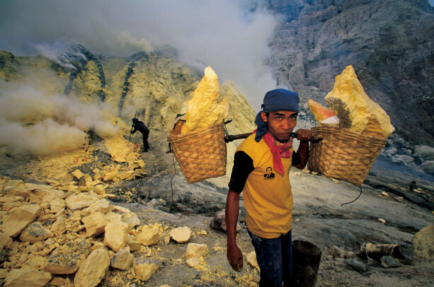 miner with baskets on his shoulder full of sulfur